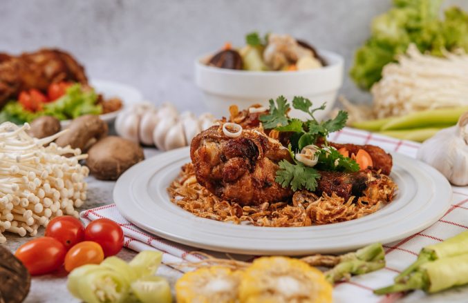 Fried chicken leg with tomato, chili, fried onion, lettuce, corn, and needle mushroom.