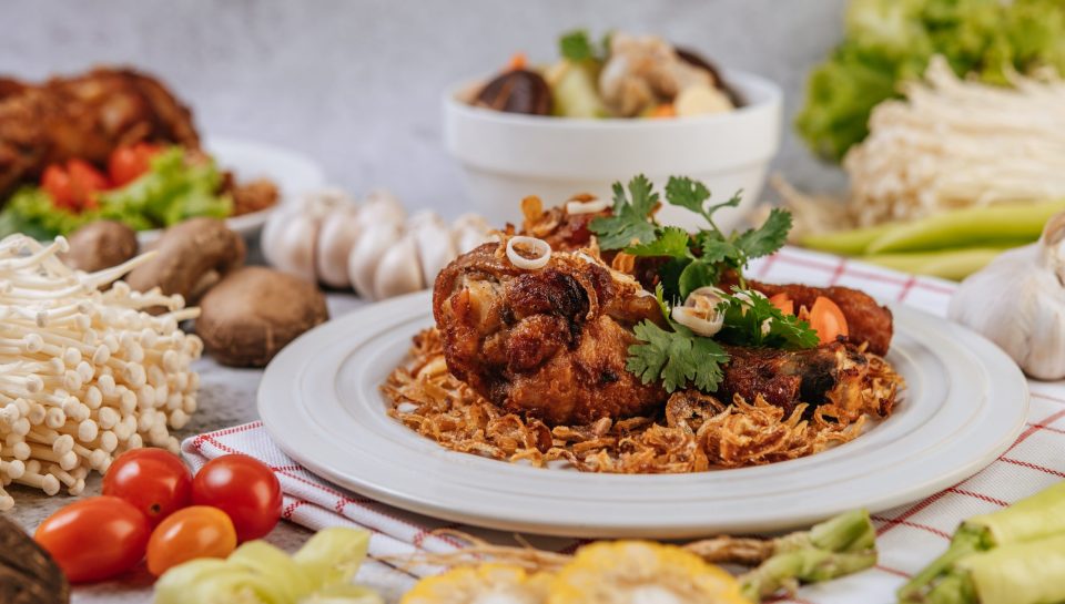 Fried chicken leg with tomato, chili, fried onion, lettuce, corn, and needle mushroom.