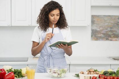 woman-writing-notebook-kitchen